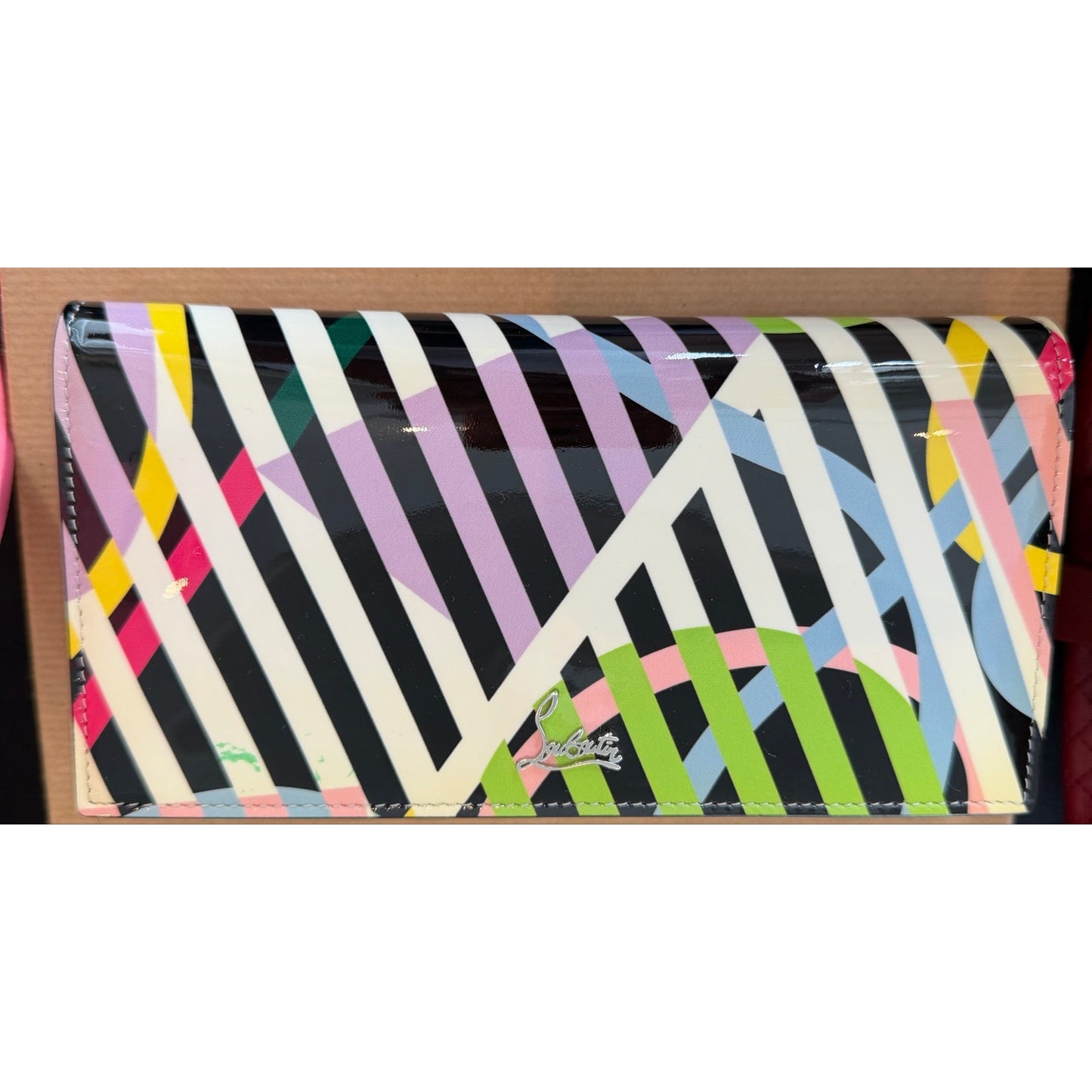 Christian Louboutin So Kate clutch features a vibrant multicolored geometric print on patent leather