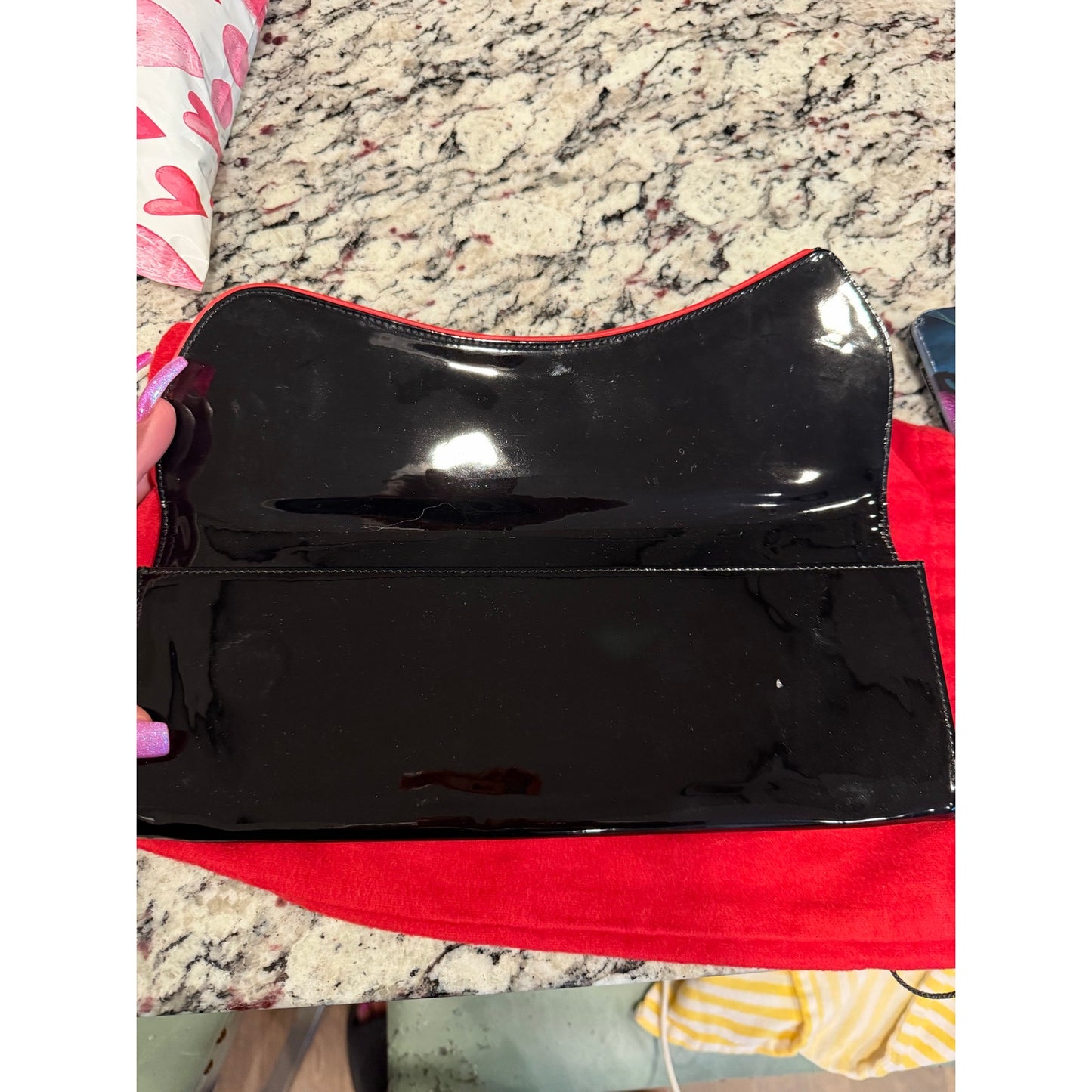 Christian Louboutin Pigalle spiked clutch is crafted from black patent leather and accented with black studs